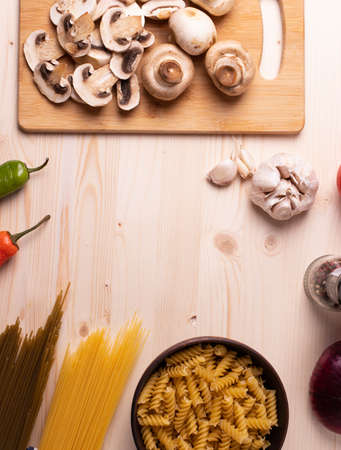 raw champignon mushrooms and tomatoes and chilli papers on the rustic wooden surfaceの写真素材