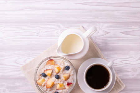 morning oat meal in a glass bowl with peachesの写真素材