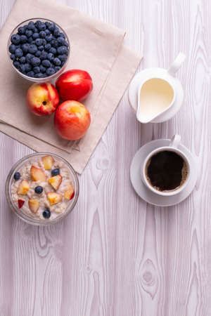 morning oat meal in a glass bowl with peachesの写真素材