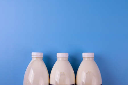 coconut lactose free milk in plastic bottles on blue surface
