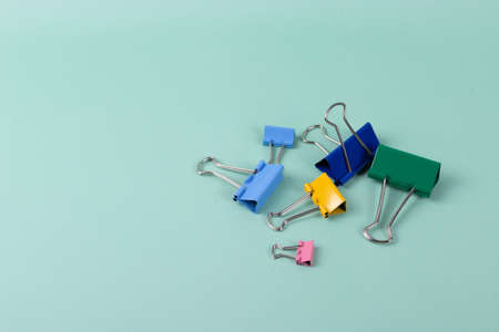 a group of vivid color office metal paper clips for paper on the pale pink mono colour background. minimalism style, top view shot.の写真素材
