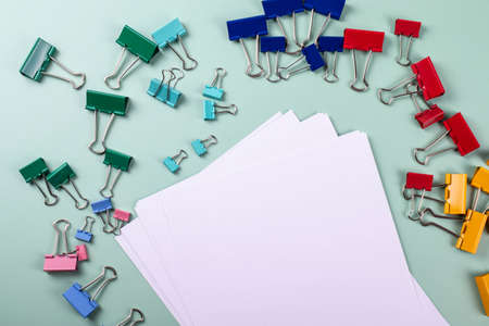 a group of vivid color office metal paper clips for paper on the pale pink mono colour background. minimalism style, top view shot.の写真素材