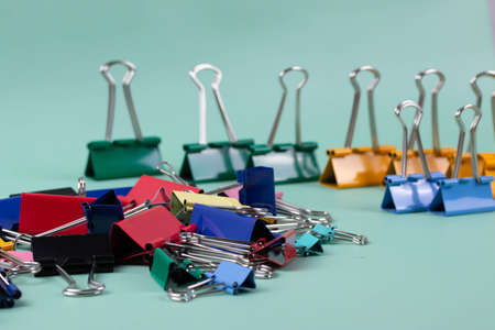 a group of vivid color office metal paper clips for paper on the pale pink mono colour background. minimalism style, top view shot.の写真素材