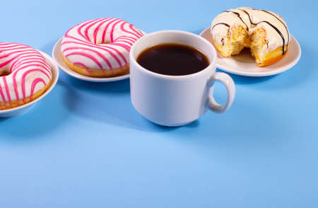 pink doughnuts and a cup of espresso on blue backgroundの写真素材