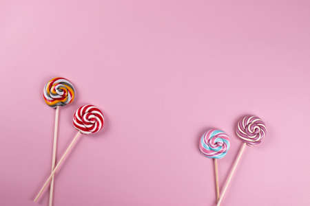 colourful sweet yummy caramel lolipops on pink background. minimalism style, copy space.の写真素材