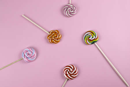 colourful sweet yummy caramel lolipops on pink background. minimalism style, copy space.の写真素材