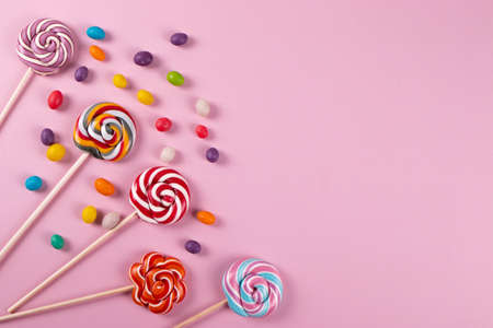 colourful sweet yummy caramel lolipops on pink background. minimalism style, copy space.の写真素材