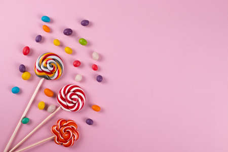 colourful sweet yummy caramel lolipops on pink background. minimalism style, copy space.の写真素材