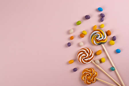 colourful sweet yummy caramel lolipops on pink background. minimalism style, copy space.の写真素材