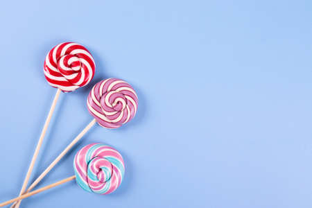 sweet yummy festive colorful lollipops on light blue background. copy space for text. minimalism styleの写真素材