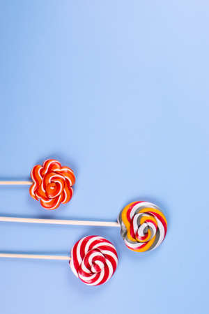 sweet yummy festive colorful lollipops on light blue background. copy space for text. minimalism styleの写真素材