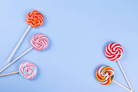 sweet yummy festive colorful lollipops on light blue background. copy space for text. minimalism styleの写真素材