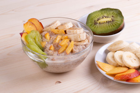a bowl of morning porridge and fruit as a healthy breakfast conceptの写真素材