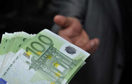 Hand gibt Geld Euroscheine 100の写真素材