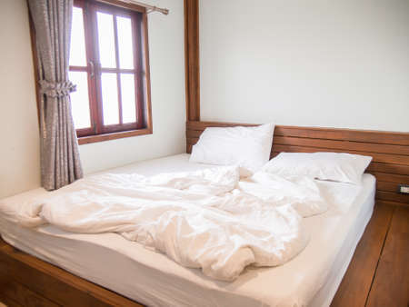White pillows on the bed and a messy blanket in the bedroom, after waking up in the morning in the...