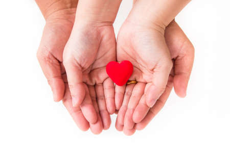 Hands of lovers with red heart in the middle.の写真素材