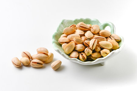 Pistachios in a bowl on a white background, isolated