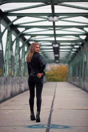 Beautiful blonde girl in black leather jacket and leggingsの写真素材