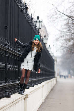 Elegant woman leaning at a fenceの写真素材
