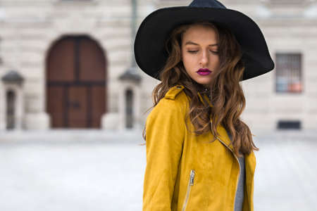 Beautiful woman with yellow jacket and hatの写真素材