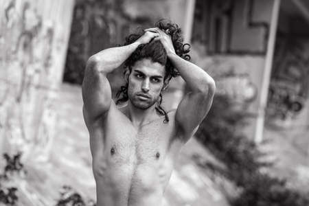 Muscular mediterranean man posing on streetの写真素材