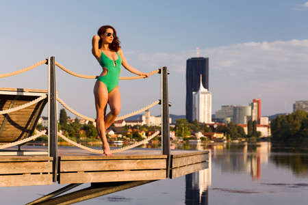 Beautiful woman enjoying the morning sun at a riverの写真素材