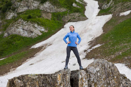 Young hiking woman standing on a rockの写真素材
