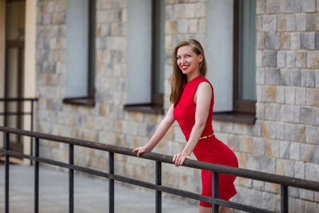 Attractive woman in red dress on streetの写真素材