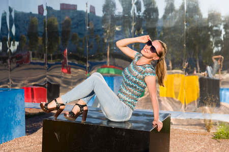 Smiling woman with sunglasses sitting on cubesの写真素材