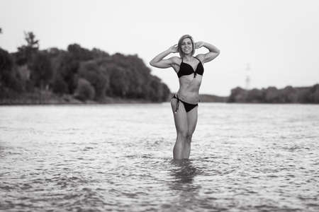 Athletic bikini girl posing at a riverの写真素材