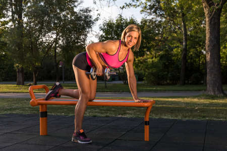 Muscular fitness girl training with dumbbellsの写真素材