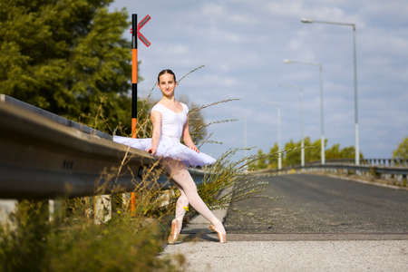 Young Ballerina sitting at a highwayの写真素材