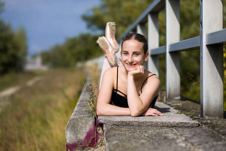 Young ballerina laying at a handrailの写真素材