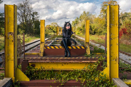 Woman in Catwoman costume on railroad waggonの写真素材