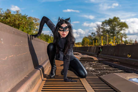 Woman in Catwoman costume on railroad waggonの写真素材