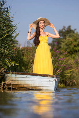 Attractive young woman with long brunette hair on a boatの写真素材