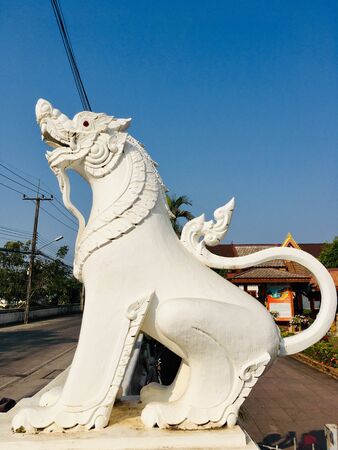 Thai lion statue in front of northern Thailand temple, Lanna traditional styleの写真素材