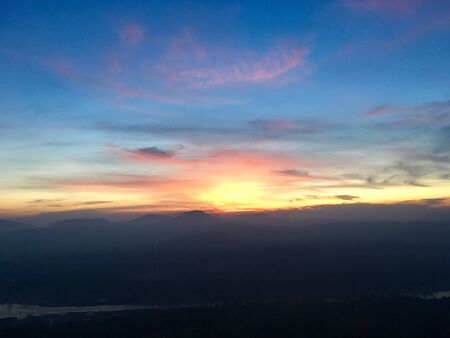 Orange light of sunrise and silhouette shadow on skyの写真素材