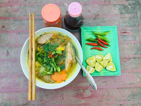 Vietnamese rice noodle soup (PHO) topped with meat, vegetable and side dishesの写真素材