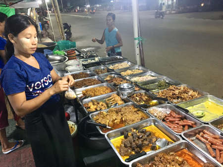 Many kind of course dishes eaten with rice Burmese style, enjoy side way local street food in Mandalay city, Myanmarのeditorial素材