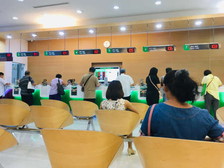Customers getting served on the counter at bank and people waiting served financial transactionsのeditorial素材