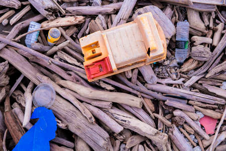 Garbage on a beach with drift wood, environmental pollution concept picture. Plastic Water Bottles. Plastic garbage.の写真素材