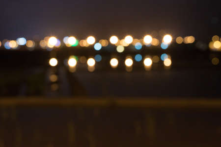 Picture blurred for abstract background, bokeh loop effect, out of focus lights of a street at night