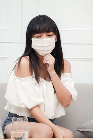 Woman suffers from cough and use face mask to protect herself and other people.の写真素材
