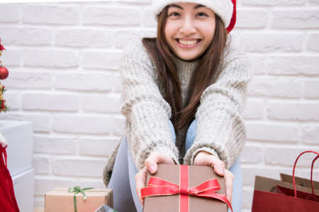Smiling young woman deliver the Christmas present box.の写真素材