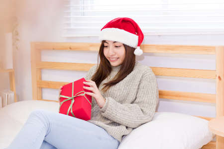 Smiling young woman with Christmas present box.