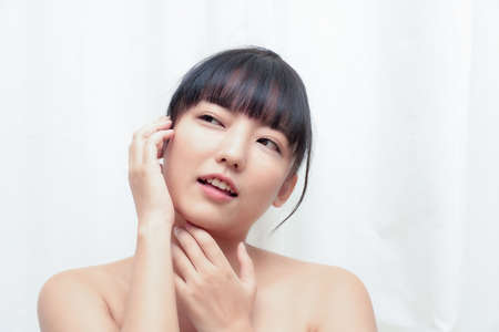 Beautiful Young Woman with Clean Fresh Skin touch own face . Facial treatment . Cosmetology , beauty and spa.の写真素材