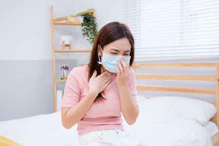 Woman suffer from cough with face mask protection.