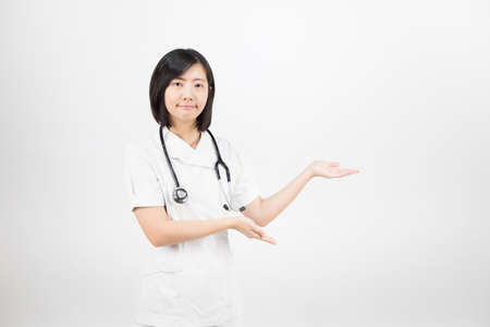 Young asian nurse with a stethoscope isolated over white background.の写真素材