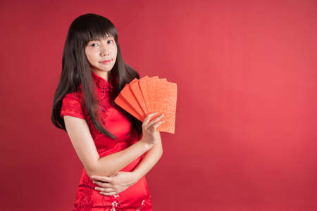 Woman in cheongsam holding 
 red envelopes.の写真素材